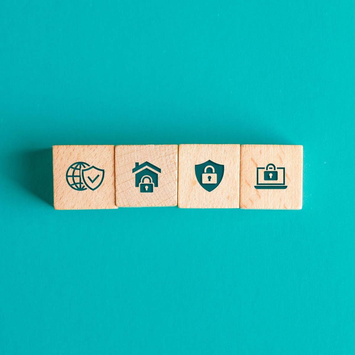 Security concept with icons on wooden blocks on turquoise background