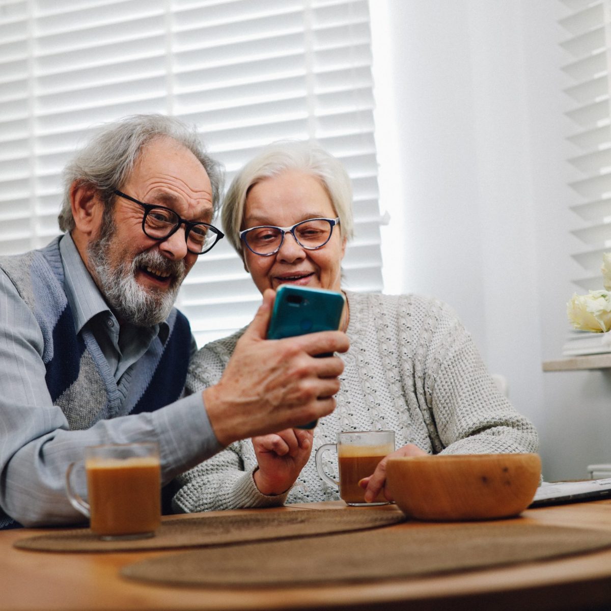 older adults using technology, adults using smartphone while drinking coffee